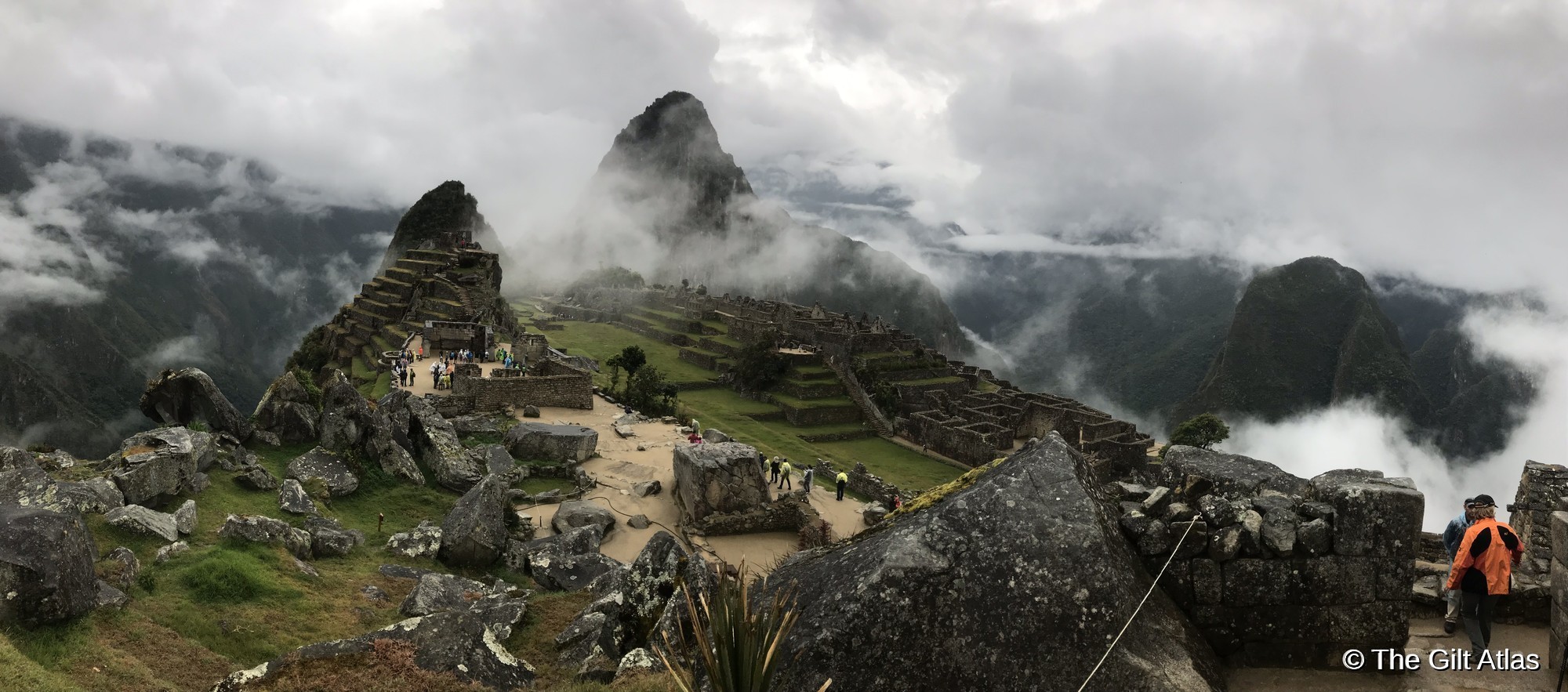 Machu Picchu citadel shrouded in early morning mist, with mountain peaks emerging through the clouds