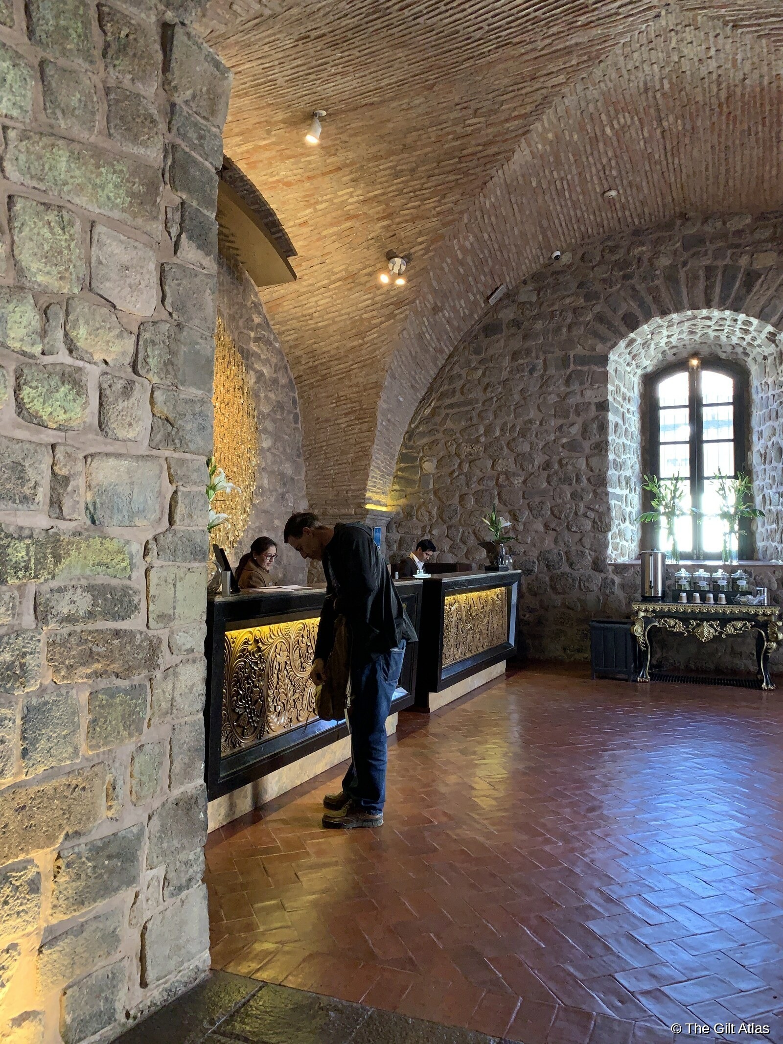 JW Marriott Cusco lobby with Inca stonework and golden check-in desk