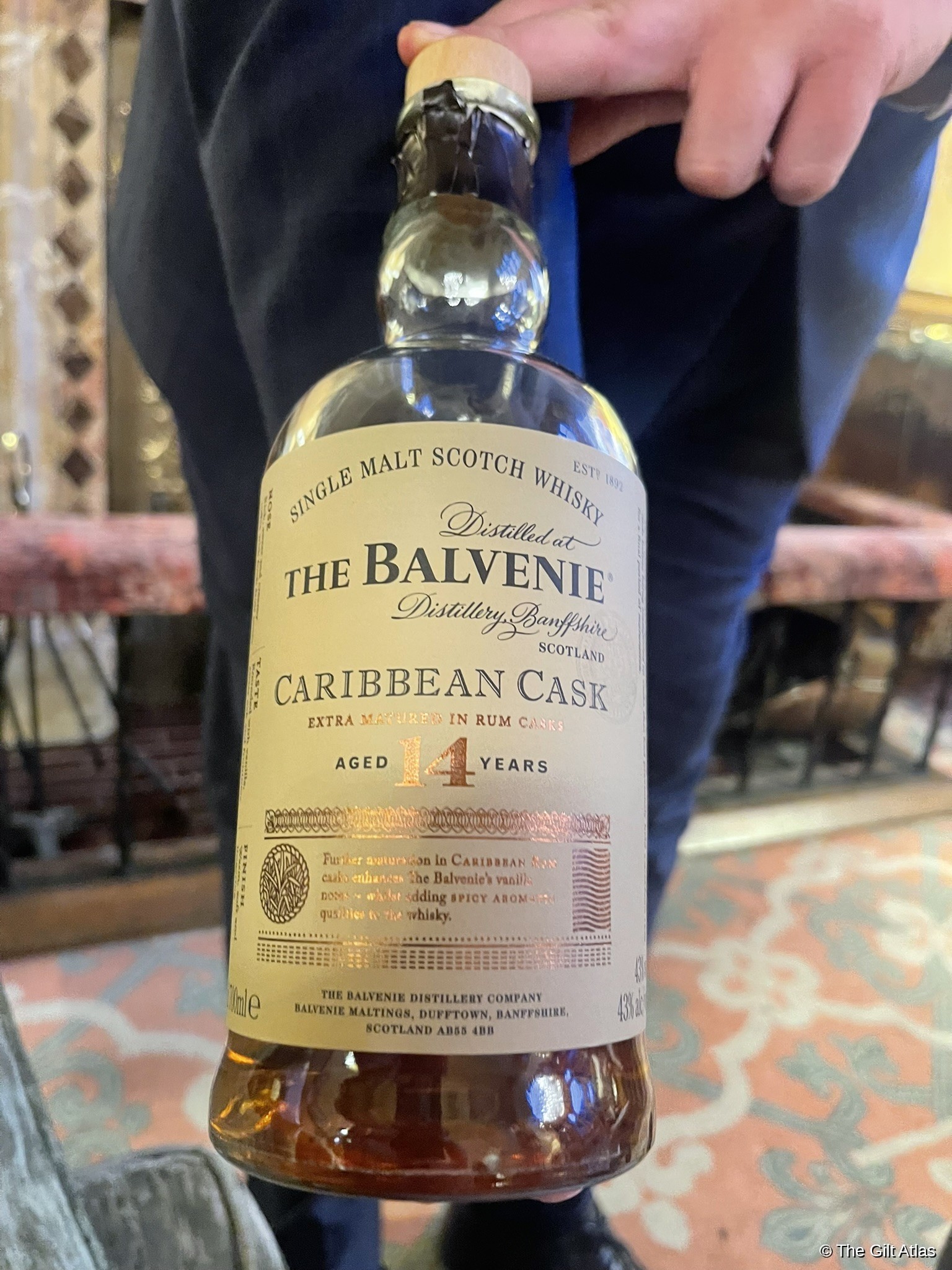 A bottle of The Balvenie Caribbean Cask 14 Year being presented in the Inverlochy Castle drawing room.
