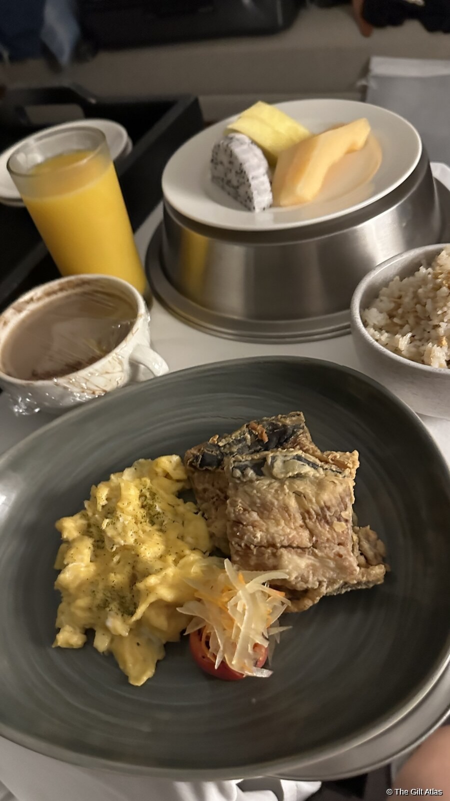 Filipino breakfast plate at Westin Manila — scrambled eggs, bangus, rice, dragonfruit, and orange juice