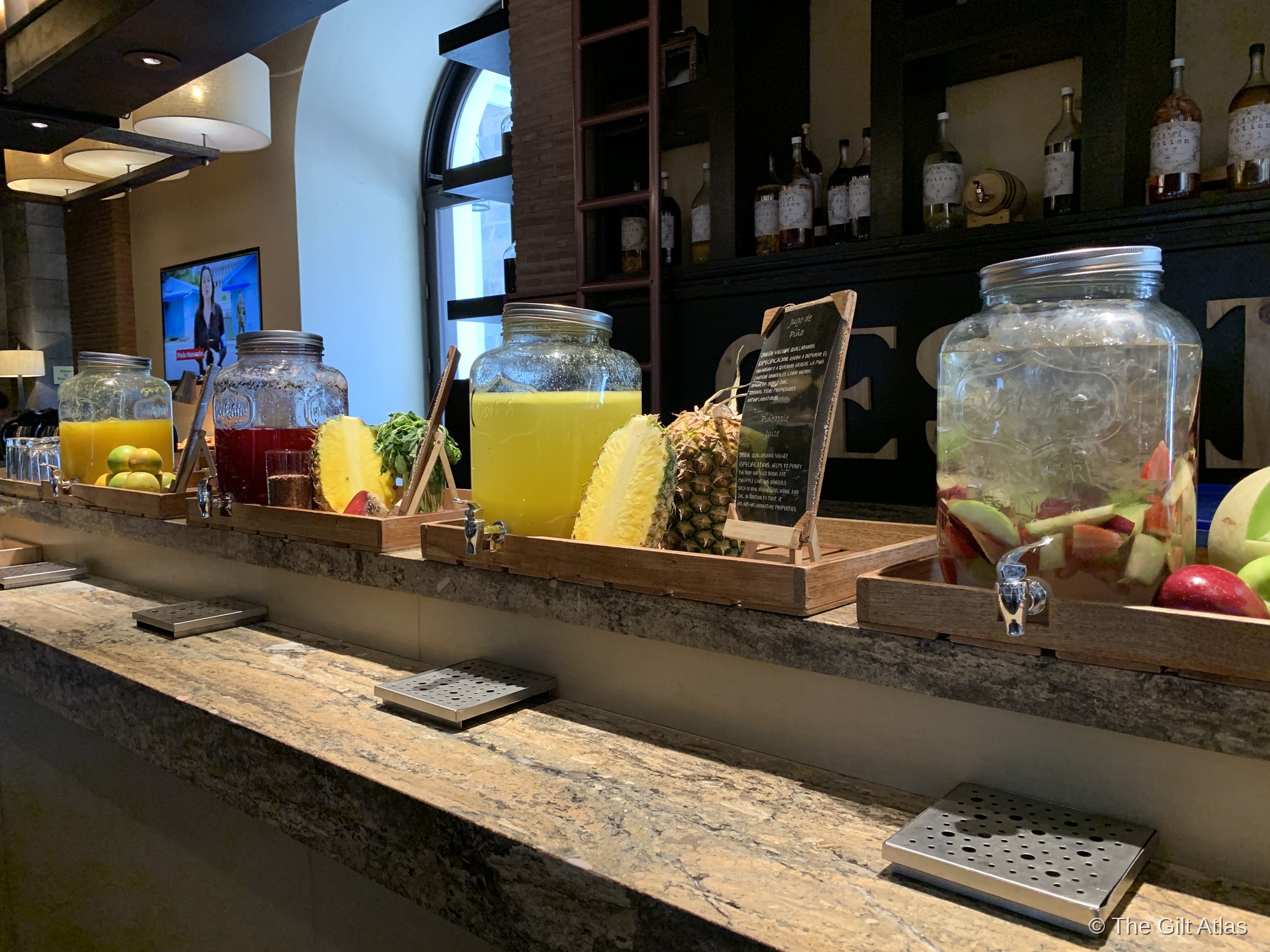 A row of glass dispensers with fresh fruit juices at the Palacio del Inka breakfast buffet