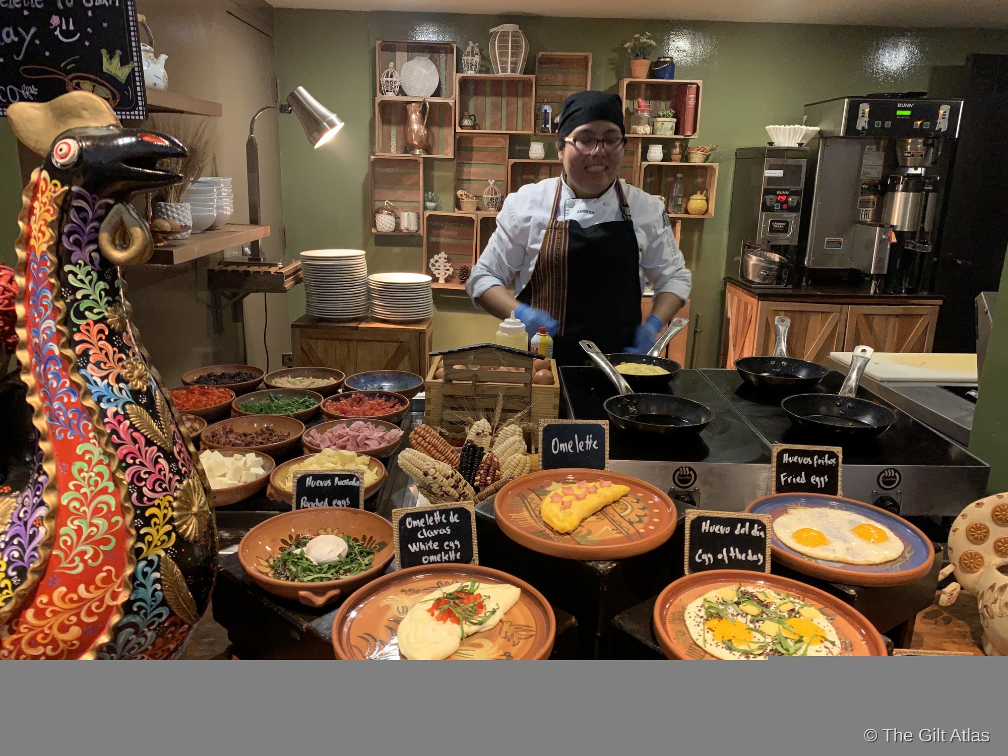 A chef preparing made-to-order omelets at a breakfast station at the Palacio del Inka, with traditional Peruvian ceramic dishes of toppings laid out