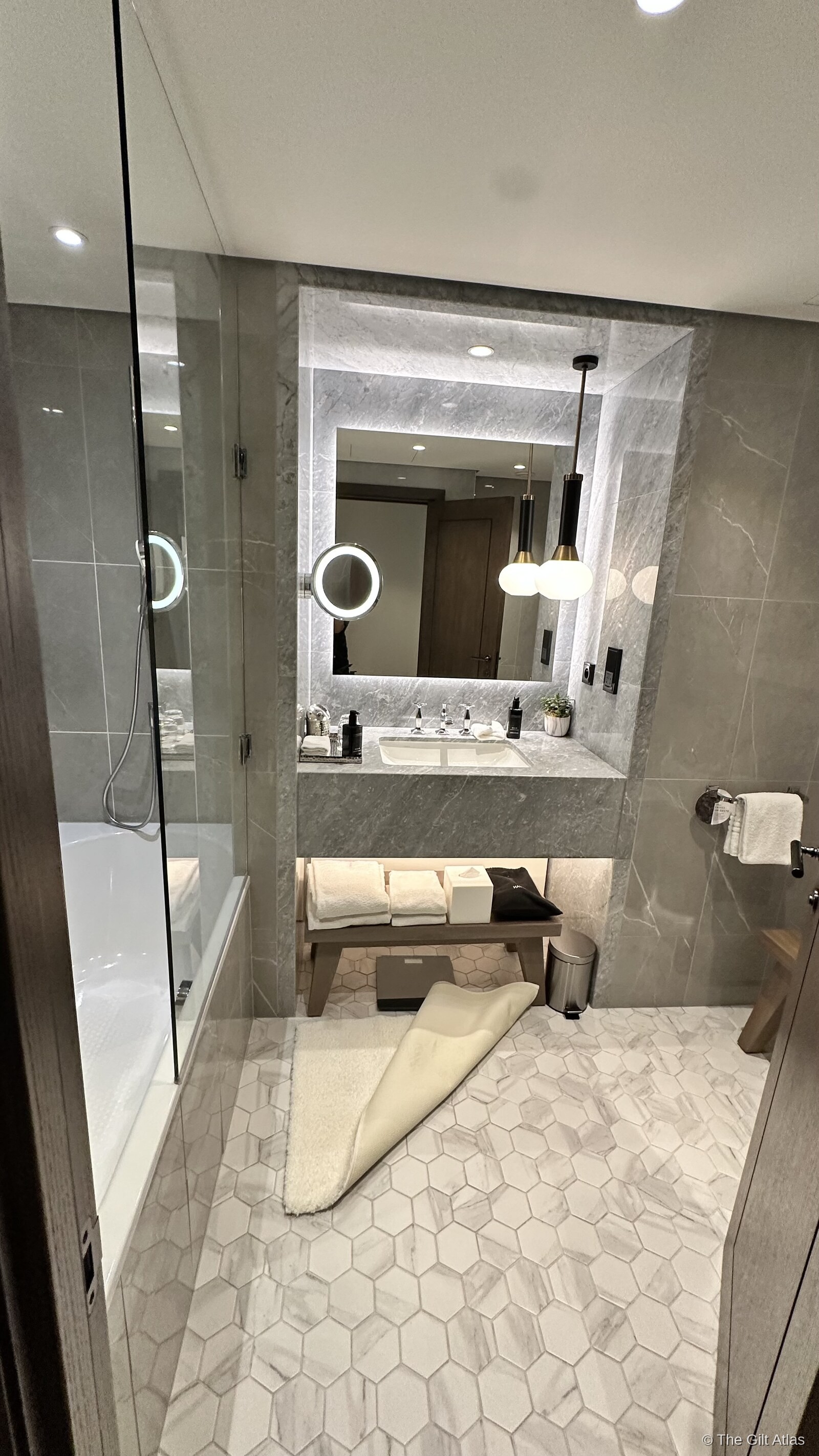 Paris Marriott Champs Élysées bathroom with marble walls, soaking tub and backlit mirror