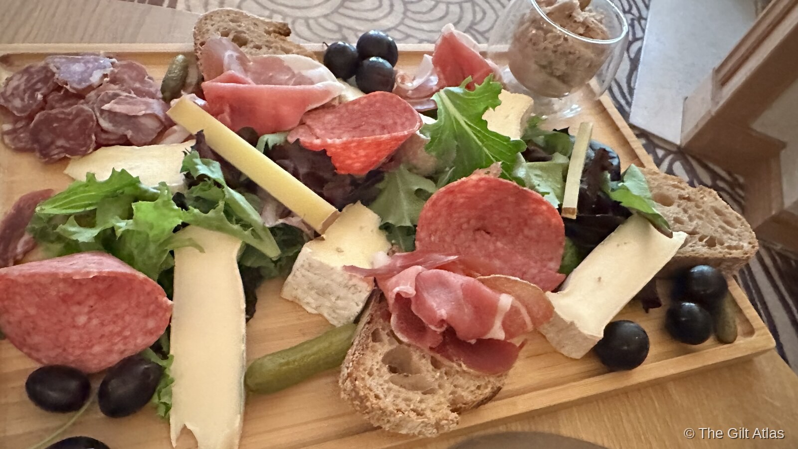 French charcuterie board with cheese, prosciutto, salami, olives and rustic bread