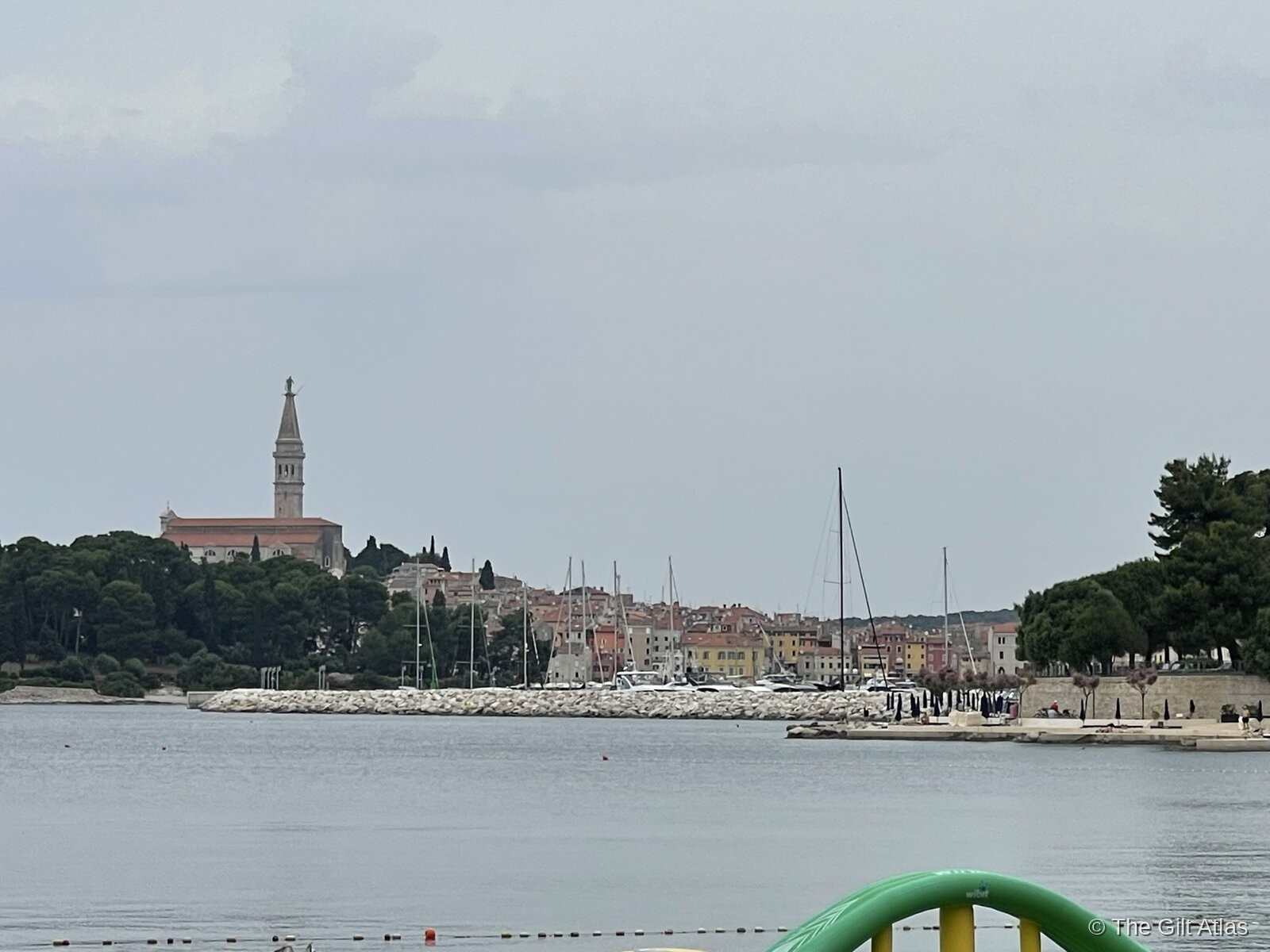 Rovinj seen from the waterfront, with the campanile of St. Euphemia rising above the old town and sailboats moored in the harbour