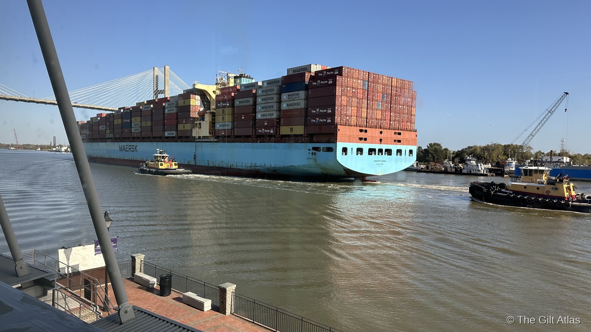 A Maersk container ship transiting the Savannah River past Plant Riverside District, with the Talmadge Bridge visible in the background