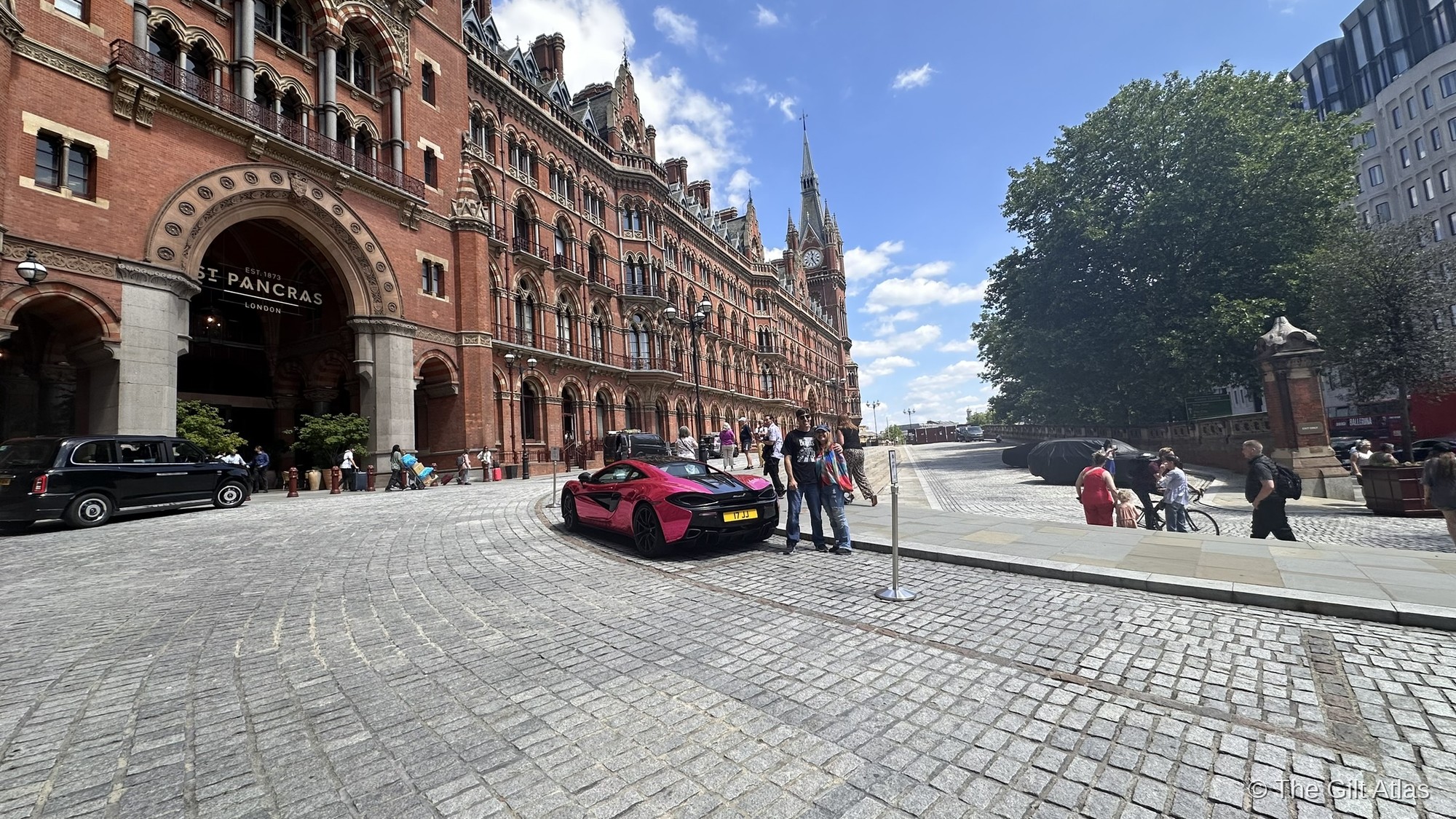 The St. Pancras Renaissance Hotel facade on Euston Road — the full Gothic terracotta elevation with clock tower, on a clear summer day.