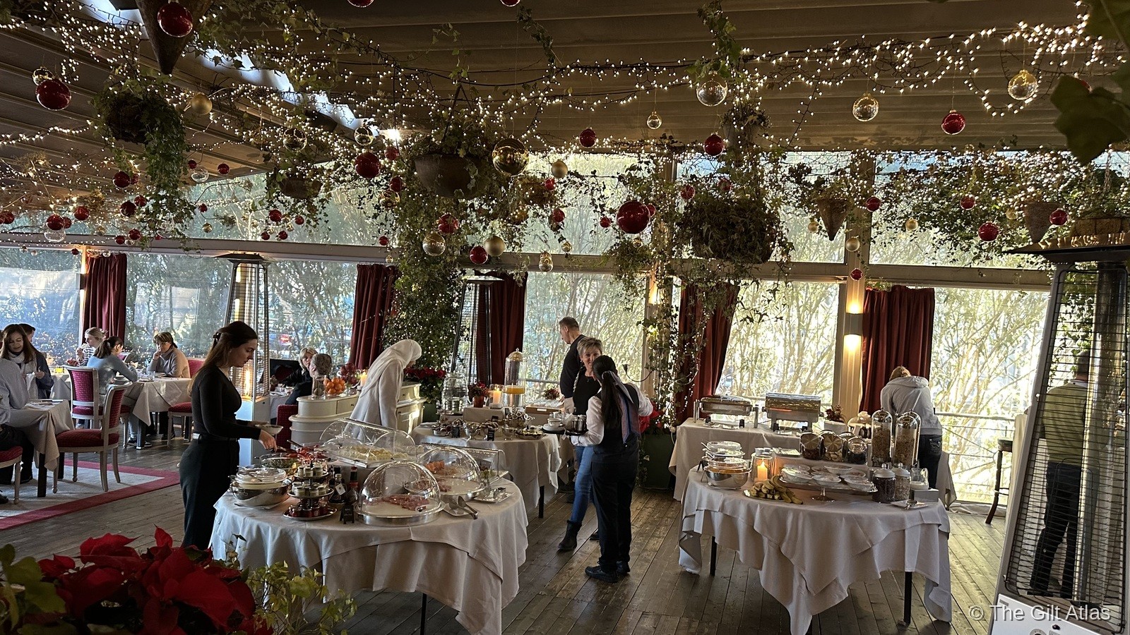 Hotel Terminus breakfast room — greenhouse-style with fairy lights, ornaments, and white-clothed tables